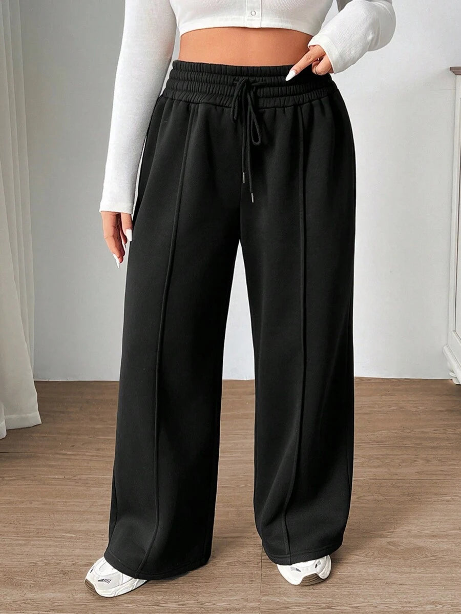 Calça Moletom Plus Size preta, cordão ajustável e caimento reto. Conforto em algodão para looks femininos casuais e versáteis.