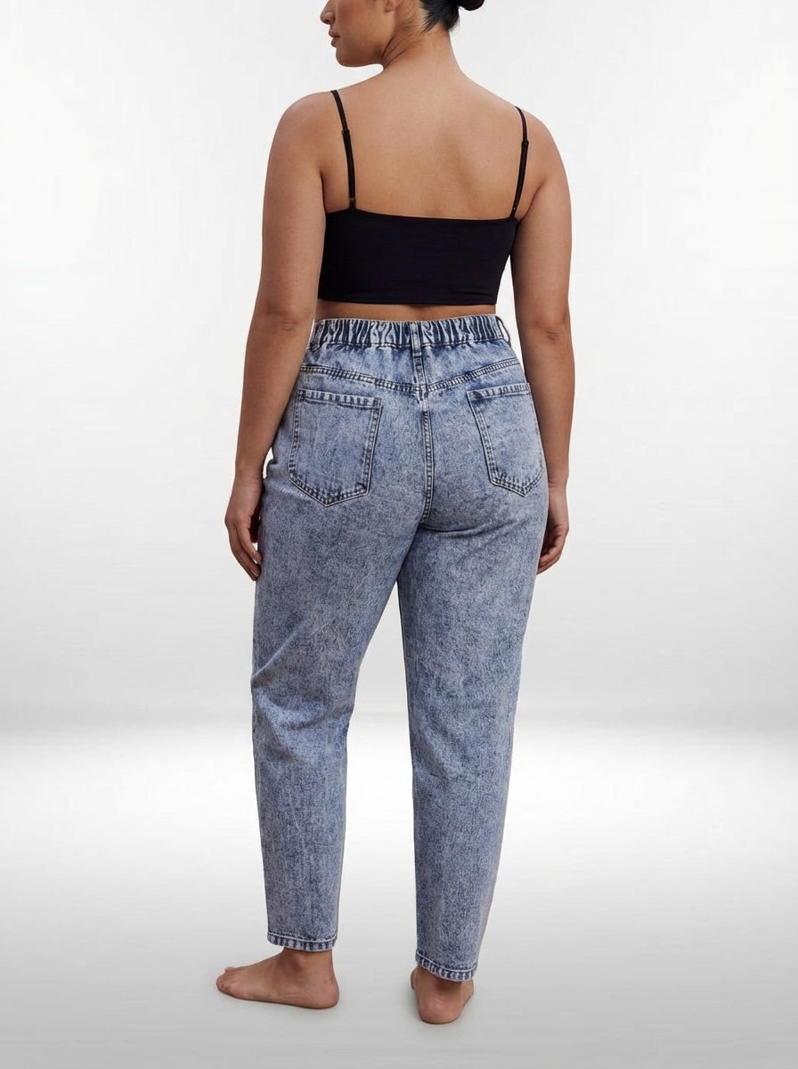 Calça jeans plus size mom fit com fechamento em zíper, botão e cintura alta que valoriza a silhueta