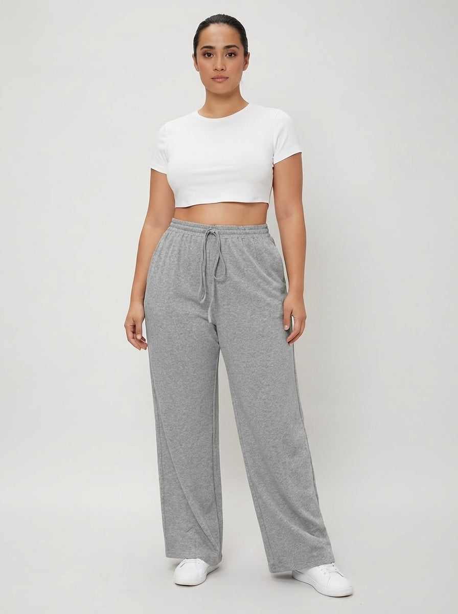 Calça moletom plus size cinza claro com perna reta, caimento solto e cintura com cordão regulável