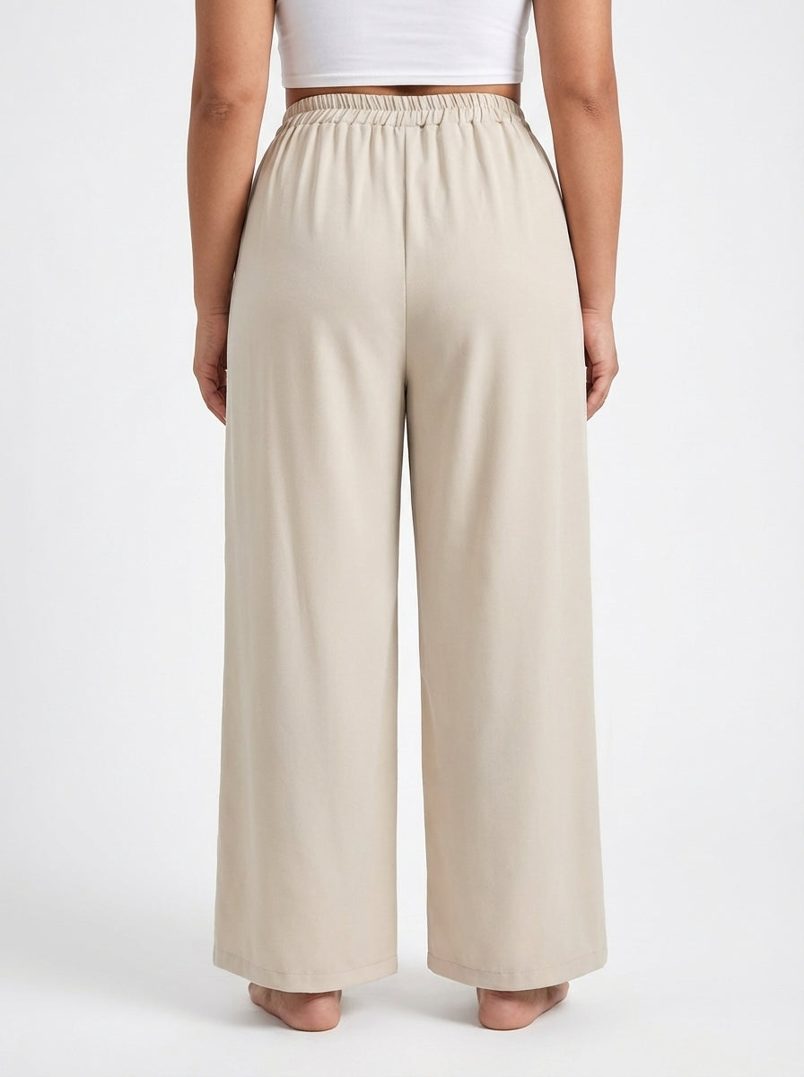 Calça plus size bege com modelagem pantalona, tecido macio e comprimento longo
