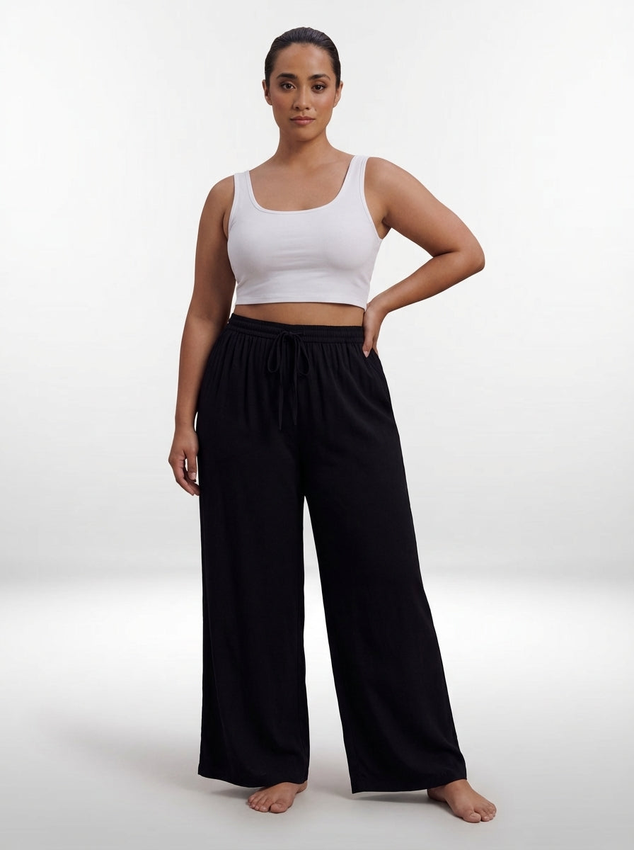 Calça pantalona plus size preta com cintura alta, pernas largas e caimento solto