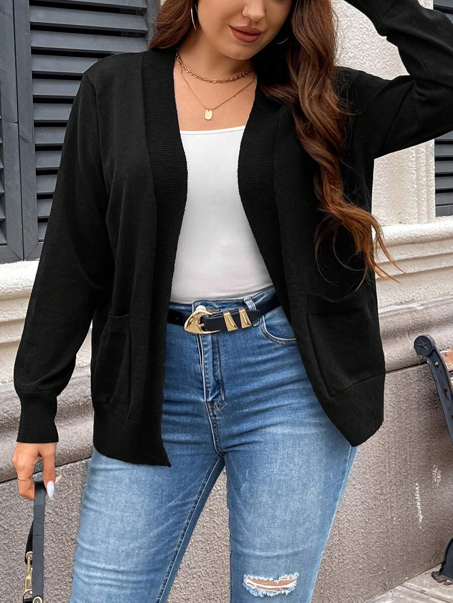 Cardigan plus size preto em lã penteada, com bolsos duplos e toque macio. Perfeito para trabalhar, passear ou combinar com vestidos e jeans.