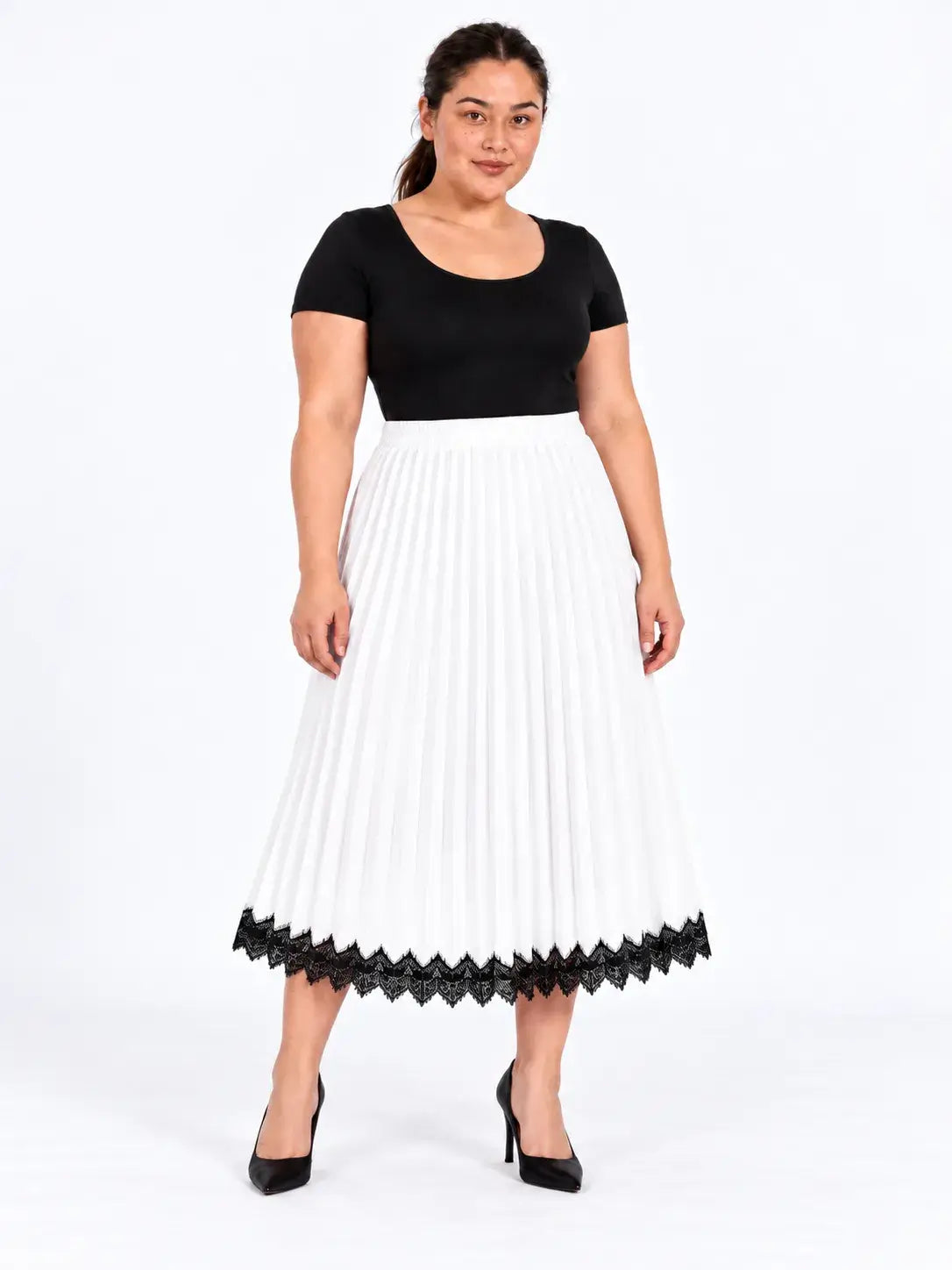 Vista frontal da saia midi plus size branca plissada, com cintura alta e barra de renda preta, combinada com blusa preta.