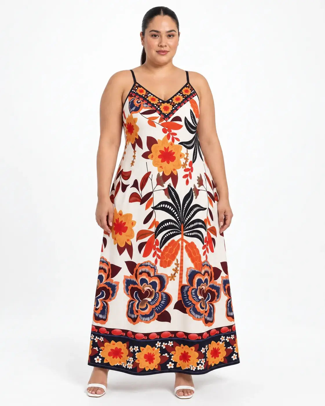 Vestido longo plus size visto de frente, com estampa botânica multicolorida, decote em V e faixa floral na barra.
