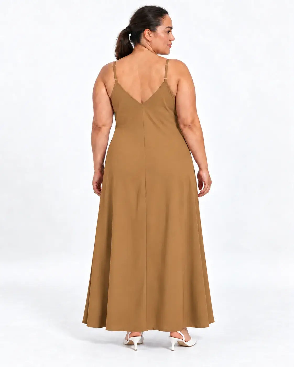 Vestido longo plus size bege visto de costas na modelo, com alças finas, decote em V e parte posterior lisa.