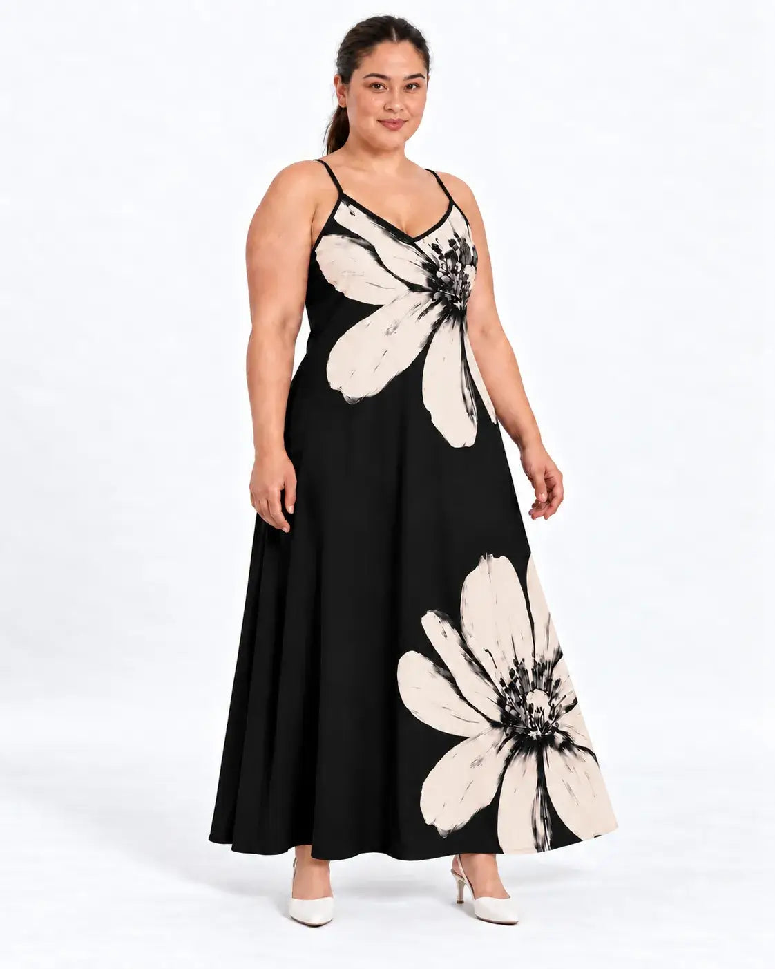 Modelo usando vestido longo plus size preto com flores claras, alças finas e decote em V, em vista frontal.