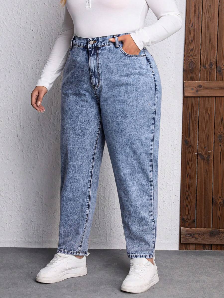 Calça Mom Fit Plus Size com cintura alta que alonga e modela. Caimento regular, detalhes práticos e jeans durável para looks elegantes e versáteis.