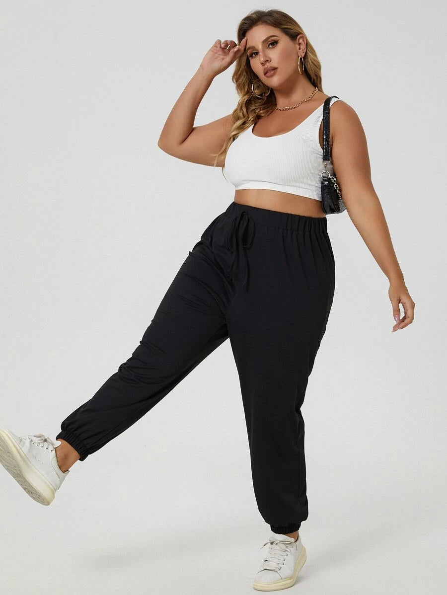 Calça jogger plus size preta, perfeita para o dia a dia. Nó frontal, cintura elástica e tecido de alta elasticidade.