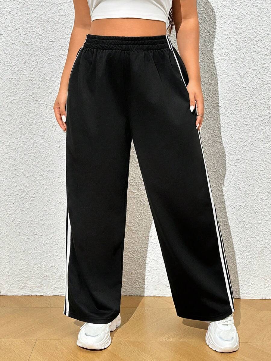 Combine estilo e mobilidade! Calça moletom plus size de perna larga, cintura elástica e listra lateral que alonga a silhueta.