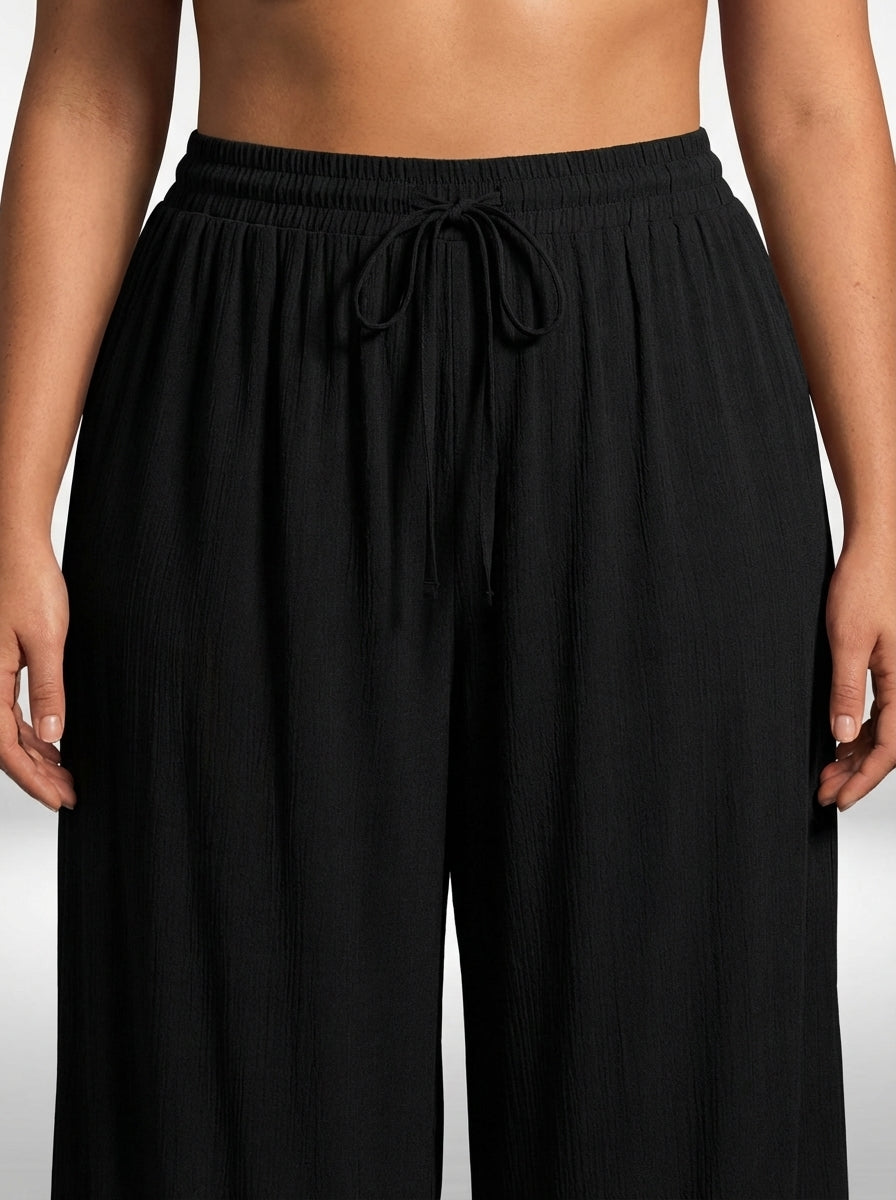 Calça plus size preta com pernas largas, bolso funcional e ajuste confortável na cintura