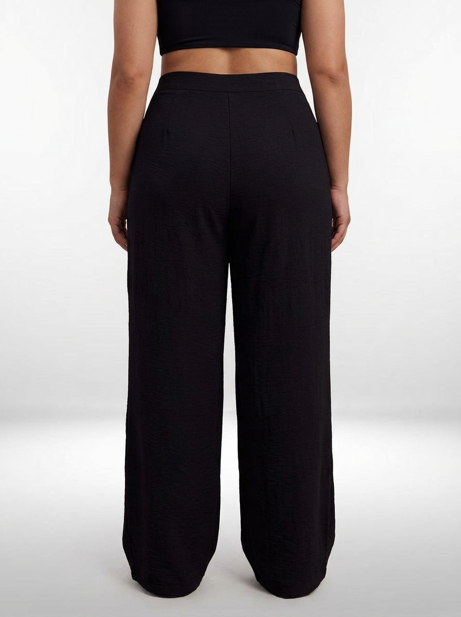 Calça plus size preta de comprimento longo com perna larga, visual casual e fechamento por zíper