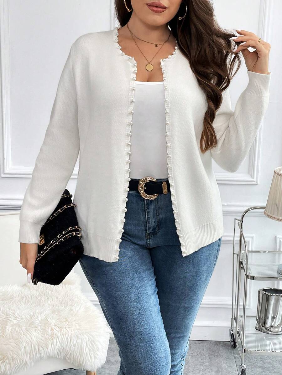 Cardigan plus size branco com pérolas, tecido de elasticidade média e caimento solto. Perfeito para mulheres que buscam elegância e conforto.