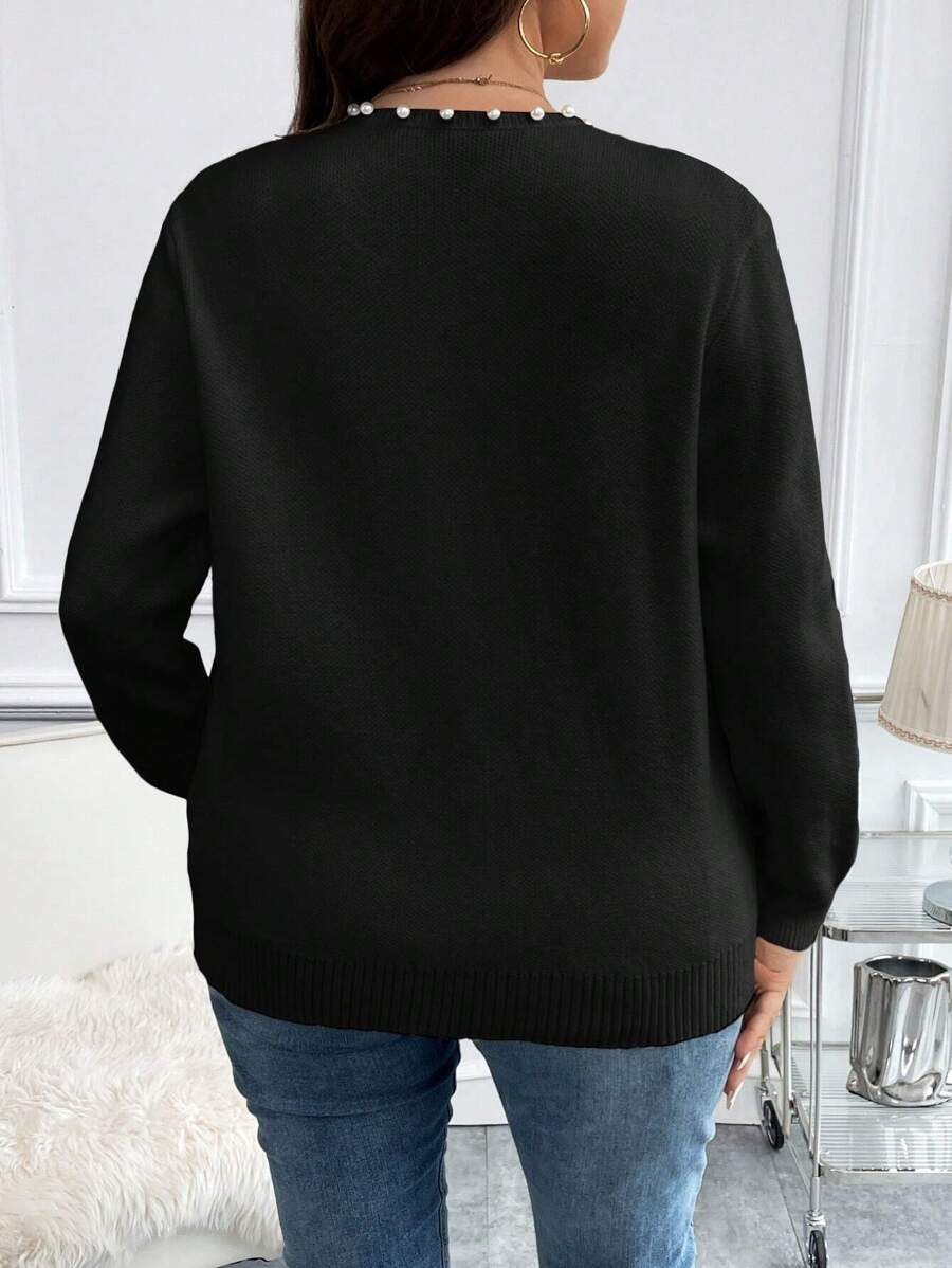 Cardigan plus size preto, manga comprida, tecido aconchegante e pérolas delicadas. Ideal para dias frios e looks casuais elegantes.