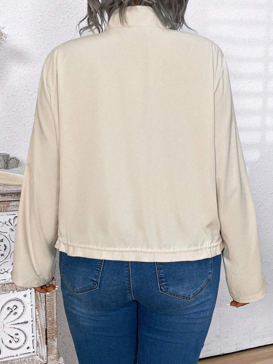 Jaqueta plus size casual com bainha com cordão, bolsos com zíper e mangas de enrolar. Ideal para looks versáteis e confortáveis.