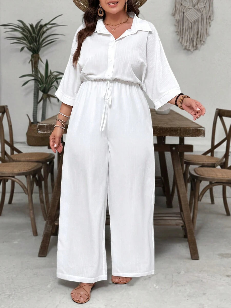 Macacão plus size com cintura marcada e manga morcego 3/4. Estilo, elegância e conforto em um único look.