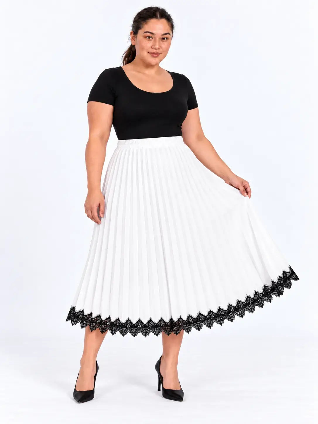 Modelo segurando a lateral da saia midi plus size branca plissada, destacando a amplitude e a renda preta na barra.