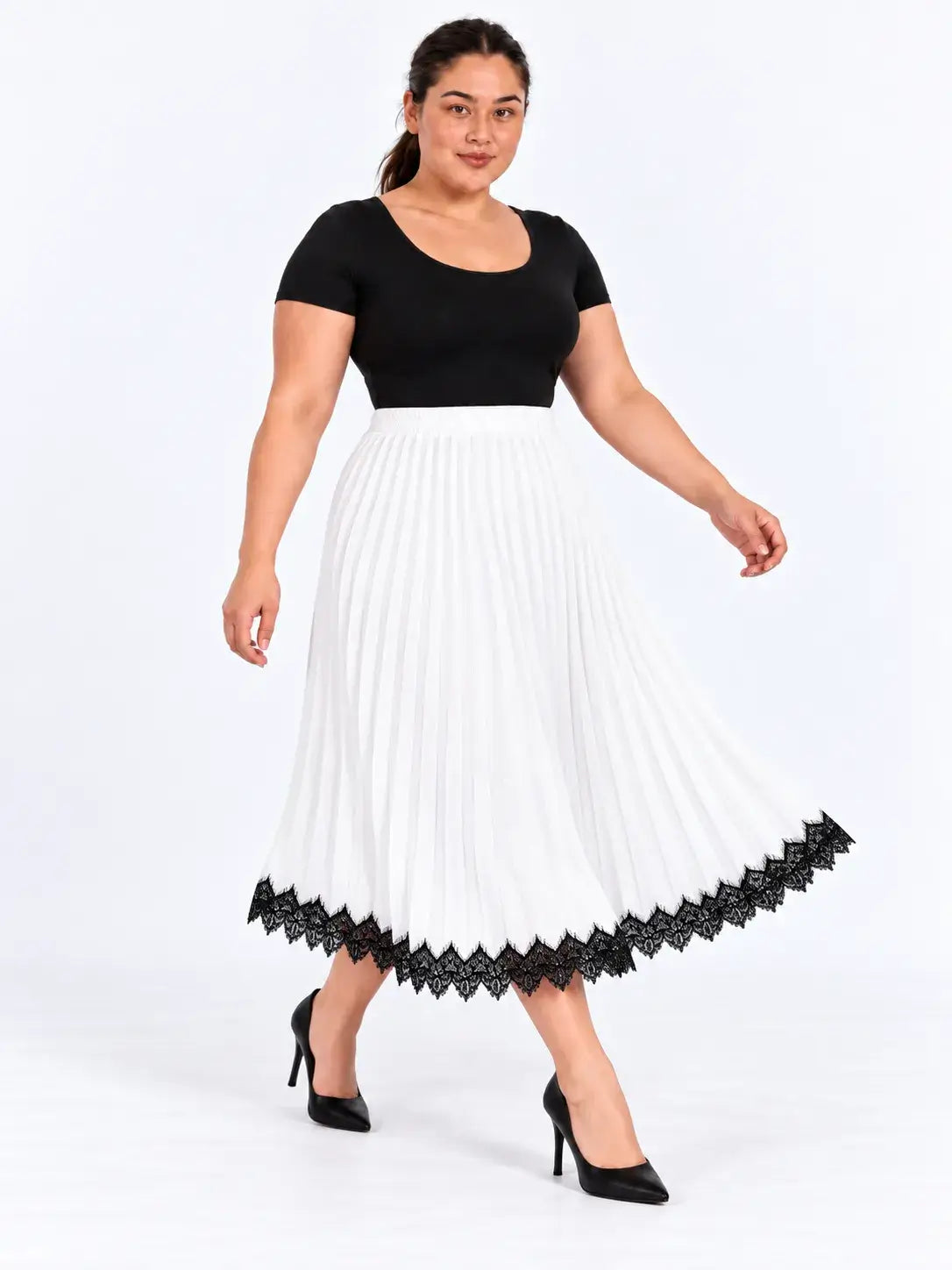 Modelo caminhando com saia midi plus size branca plissada, mostrando o movimento do tecido e a renda preta na barra.