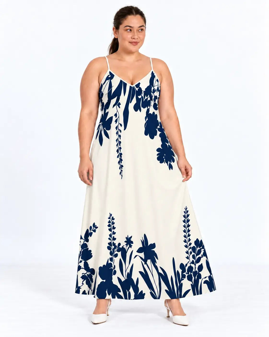 Vestido longo plus size de alças finas, com fundo claro e estampa botânica azul-marinho no busto e na barra, visto de frente.