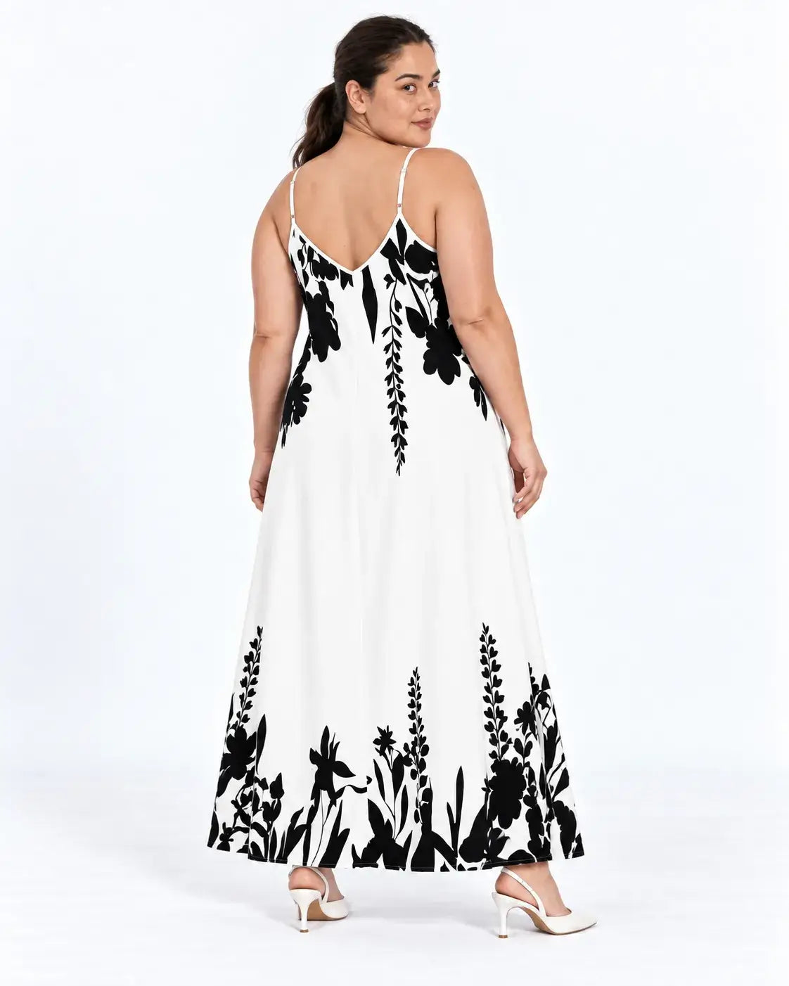Vestido longo plus size branco visto de costas, com alças finas, decote em V e estampa botânica preta na barra.