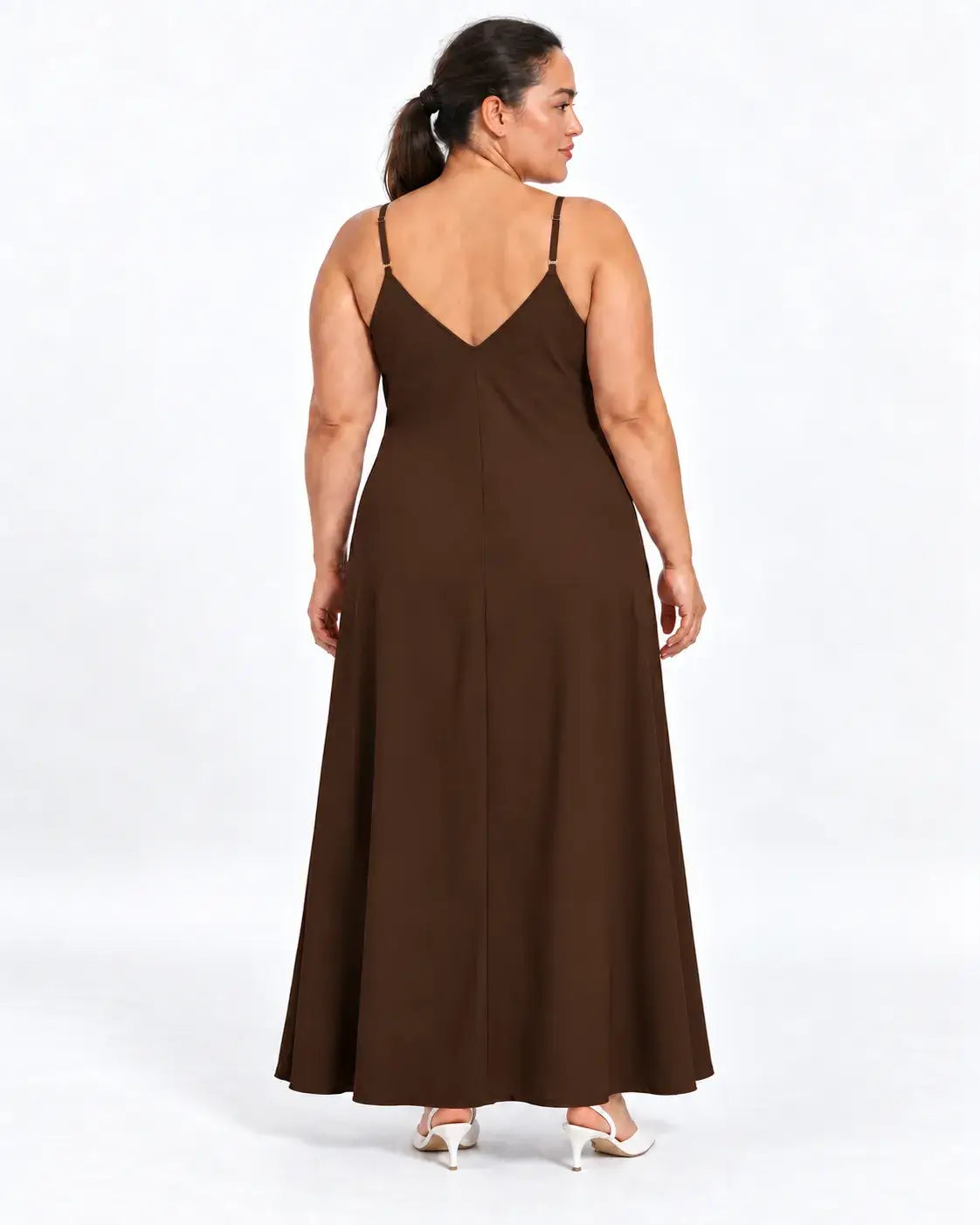 Vestido longo plus size marrom visto de costas na modelo, com alças finas, decote em V e parte posterior lisa.