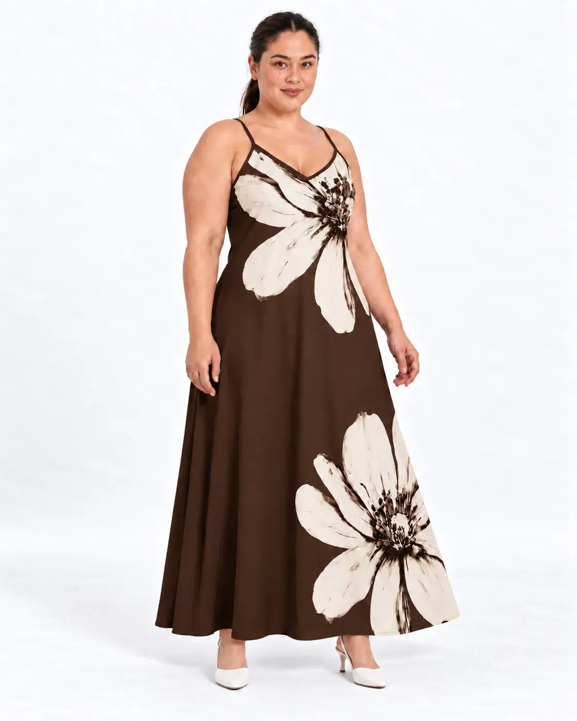 Modelo usando vestido longo plus size marrom com flores claras, alças finas e decote em V, em vista frontal.
