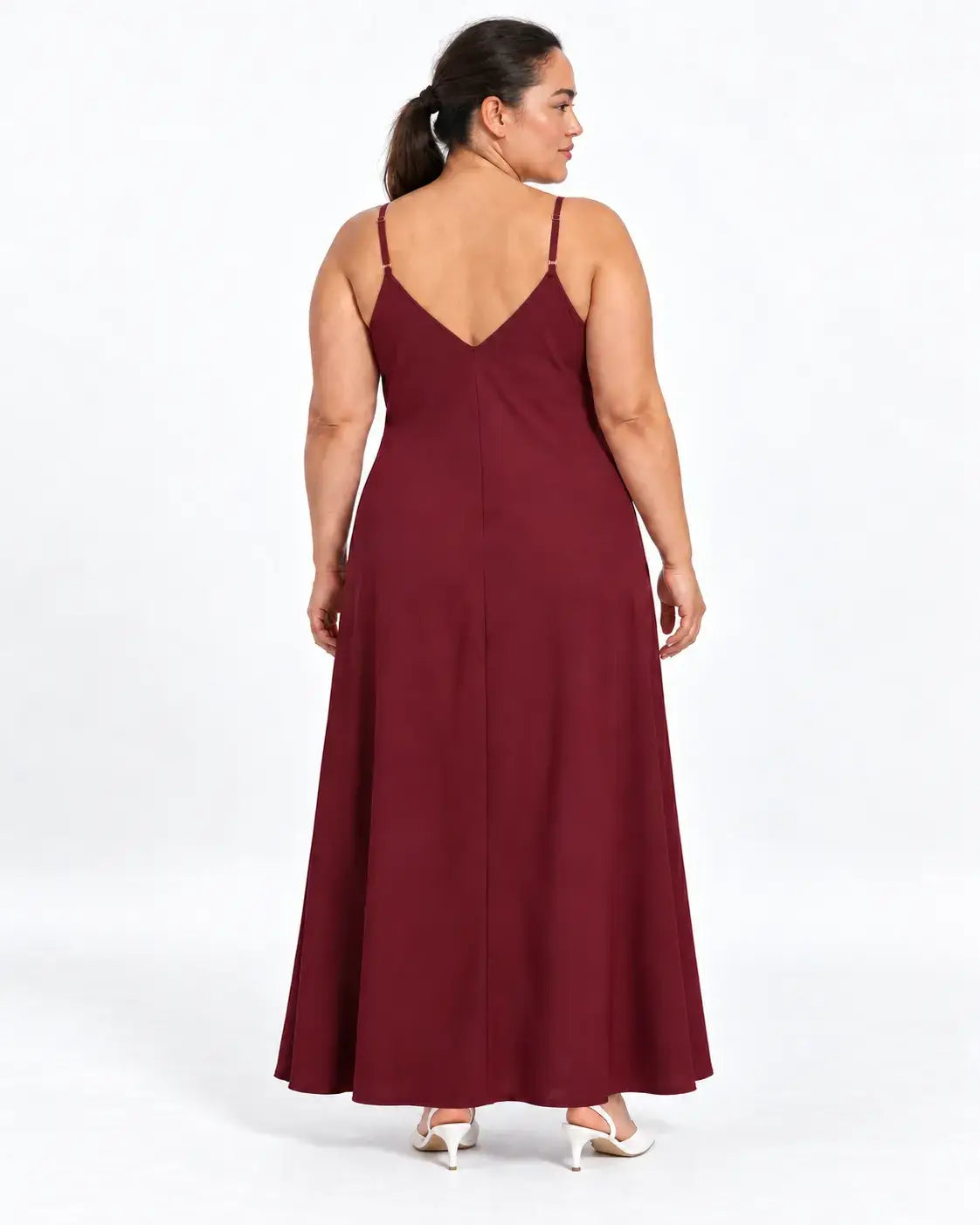 Vestido longo plus size vinho visto de costas na modelo, com alças finas, decote em V e parte posterior lisa.