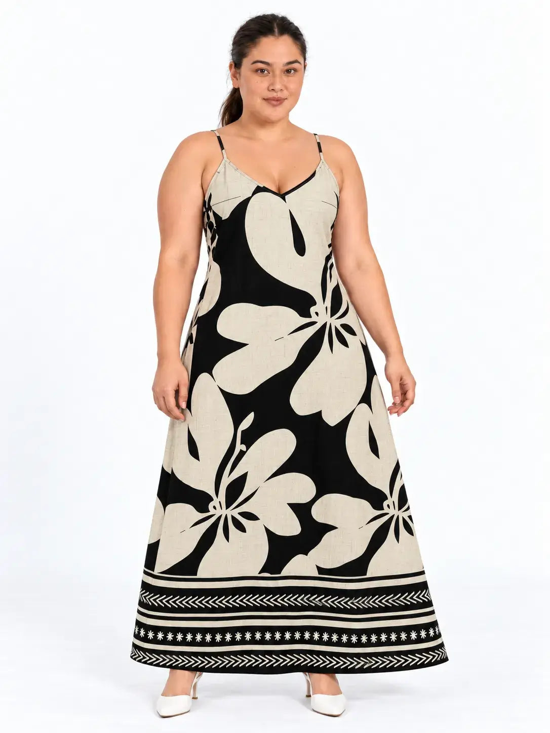 Vestido longo plus size floral boho bege e preto visto de frente, com flores grandes e faixas geométricas na barra.